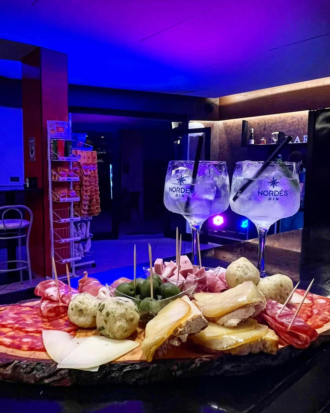 Tagliere di salumi e formaggi con cocktail in un locale Karma